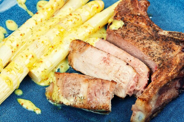 Un filete a la parrilla con espárragos en el plato.