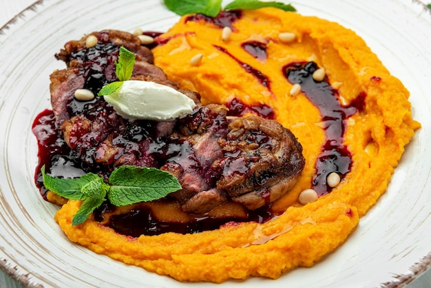 Filete de pato en salsa de cerezas con puré de calabaza Sirviendo comida en un restaurante