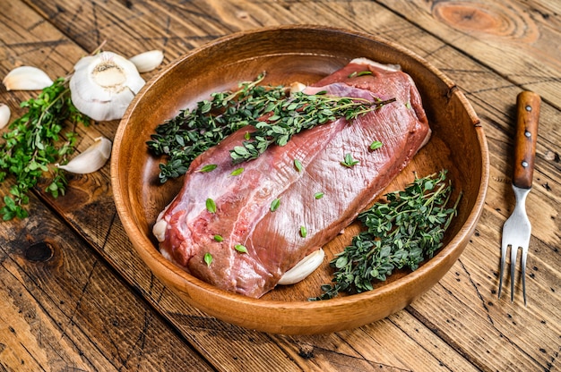 Filete de pechuga de carne de pato de ave cruda sin cocer con hierbas. mesa de madera. Vista superior.