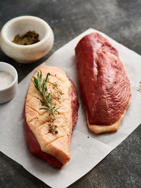 Filete de pechuga de pato crudo para cocinar en el papel blanco