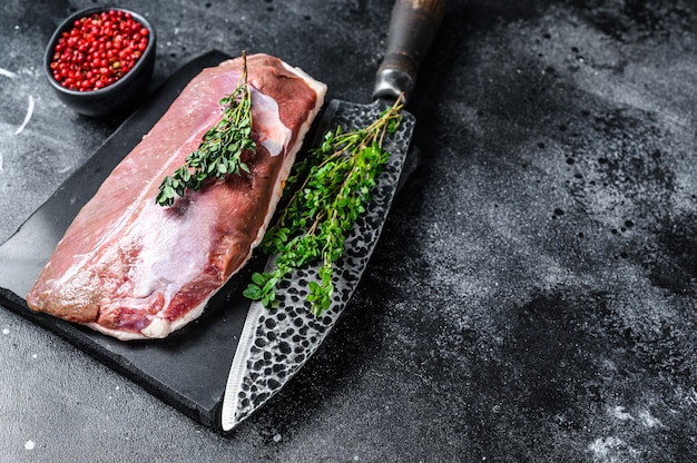 Filete de pechuga de pato crudo sobre una tabla de mármol.