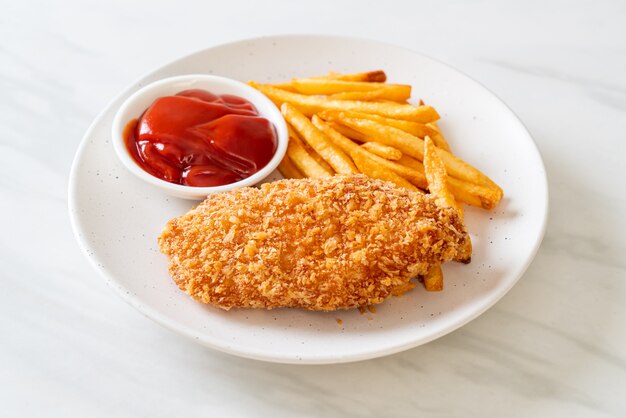 Filete de pechuga de pollo frito con papas fritas y salsa de tomate