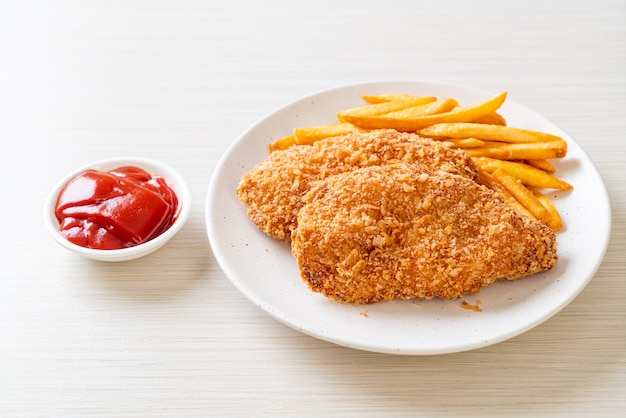 Filete de pechuga de pollo frito con papas fritas y salsa de tomate