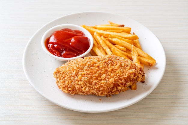 Filete de pechuga de pollo frito con papas fritas y salsa de tomate