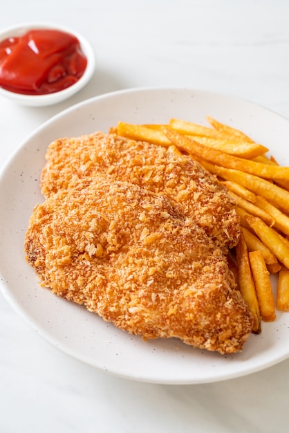 Filete de pechuga de pollo frito con papas fritas y salsa de tomate