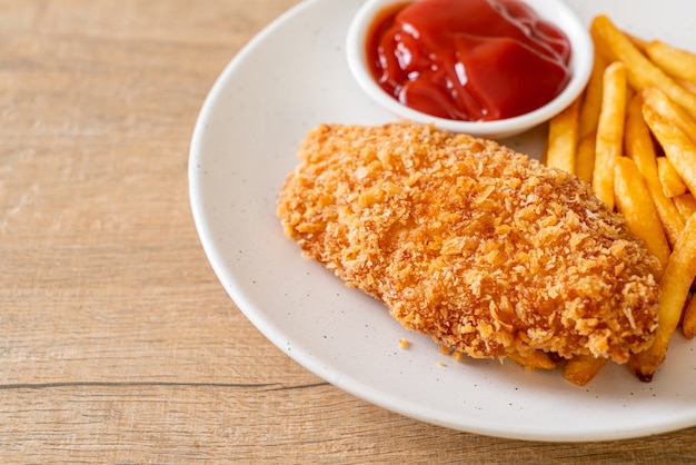 Filete de pechuga de pollo frito con papas fritas y salsa de tomate