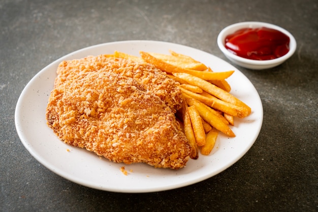 Filete de pechuga de pollo frito con papas fritas y salsa de tomate