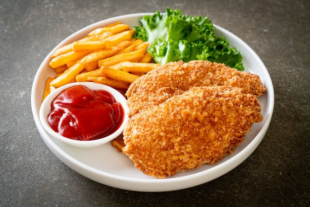 Filete de pechuga de pollo frito con papas fritas y salsa de tomate