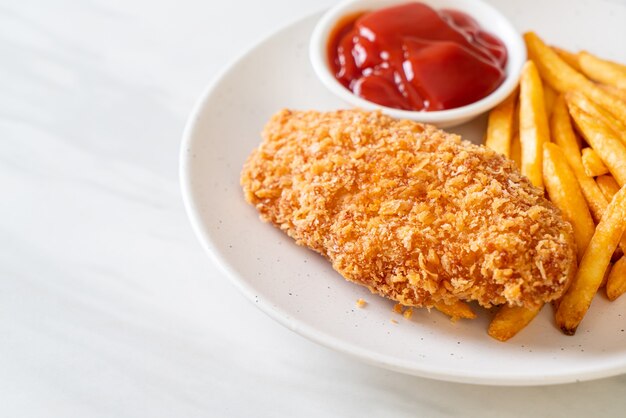 Filete de pechuga de pollo frito con papas fritas y salsa de tomate