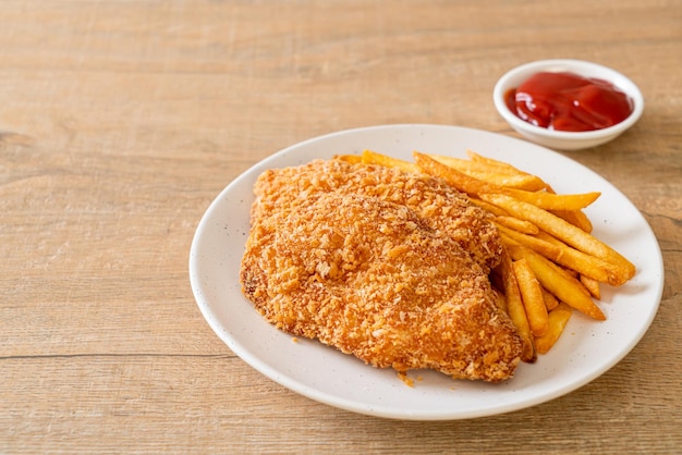 Filete de pechuga de pollo frito con papas fritas y salsa de tomate