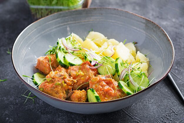 Filete de pescado al vapor con salsa de tomates, patatas hervidas y ensalada de pepino fresco. Comida dietética. Comida cuaresmal.