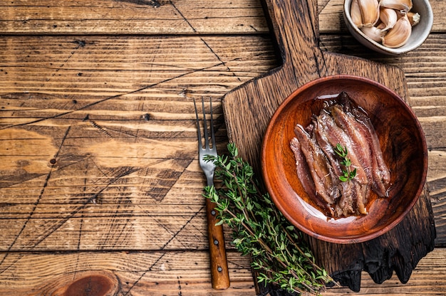 Filete de pescado de anchoas enlatadas en un cuenco de madera