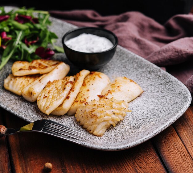 Filete de pescado blanco frito con rúcula