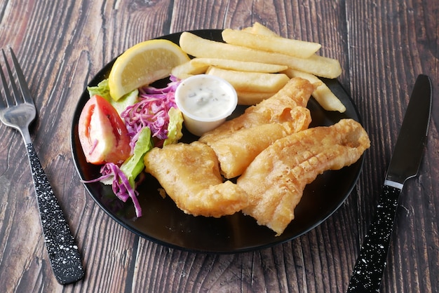 Filete de pescado con chips de limón y puré de papas en la mesa