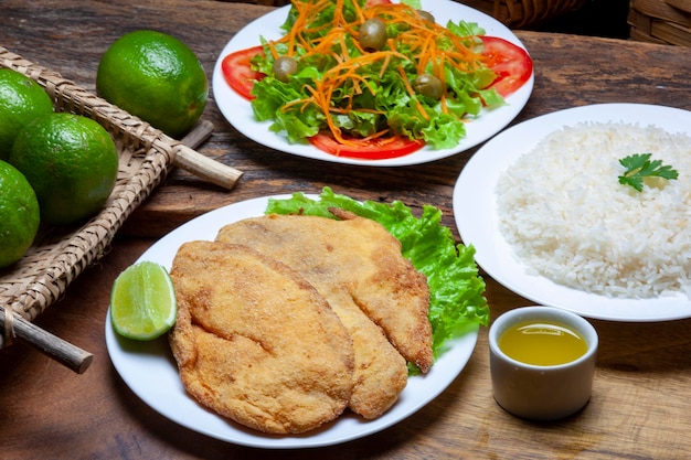 Filete de pescado empanado con ensalada de arroz y limón