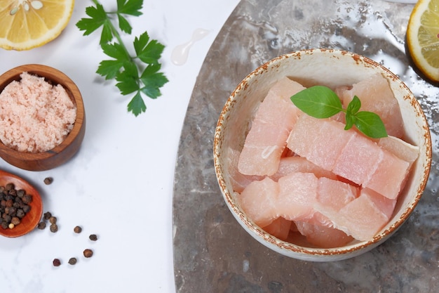 Filete de pescado fresco Pangasius dory con ingrediente sobre fondo blanco.