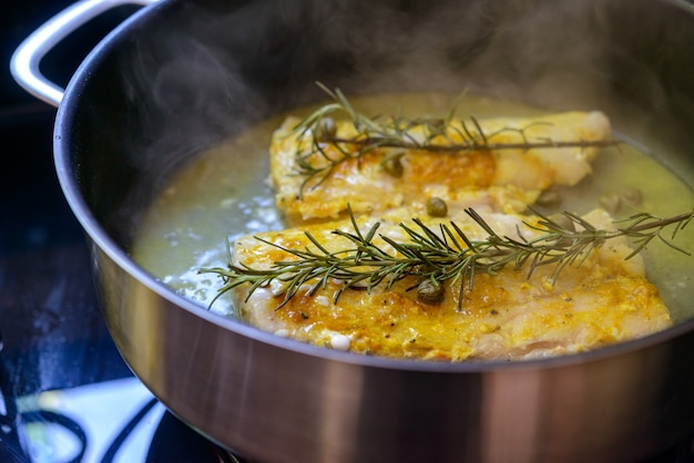 Filete de pescado frito en sartén con romero y alcaparras