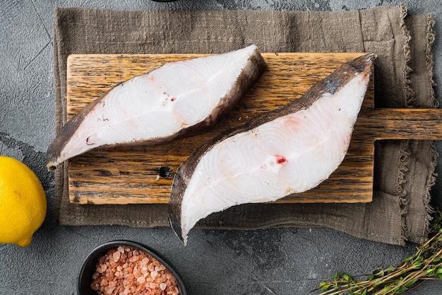 Filete de pescado de halibut fresco crudo con ingredientes y hierbas de romero sobre fondo de mesa de piedra gris vista superior plana