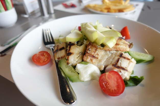 Filete de pescado a la plancha con ensalada en un plato