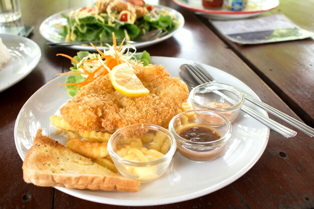 Filete de pescado rebozado con ensalada y vegetales