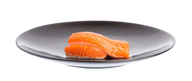 Filete de pescado rojo salmón crudo fresco en un plato aislado sobre un fondo blanco.