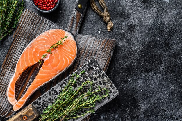 Filete de pescado salmón crudo sobre tabla de cortar rústica de madera