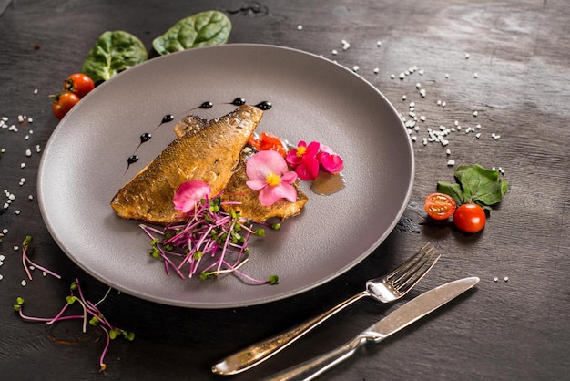 Filete de pescado con verduras sobre fondo de madera