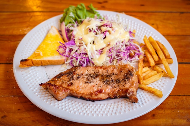 Filete de pimienta negro servido con ensalada de verduras.