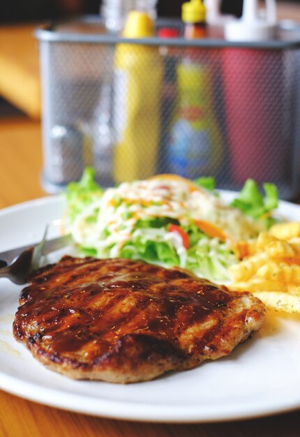 Filete de pimienta de porkchop del primer con la ensalada y frenchfried