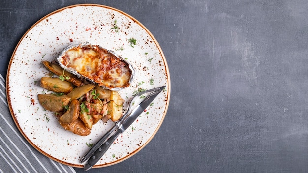 Filete de pollo al horno con tomates, guarnición de mozzarella con gajos de papa. Vista superior. Copia espacio