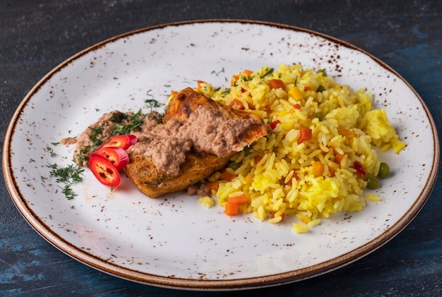 Filete de pollo y arroz con verduras en un plato