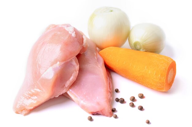 Filete de pollo, cebolla y zanahoria aislado sobre un fondo blanco. Ingredientes para cocinar