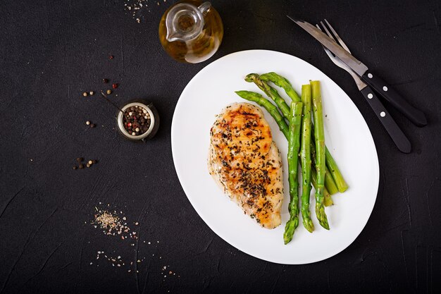 Filete de pollo cocido a la parrilla y guarnición de espárragos.