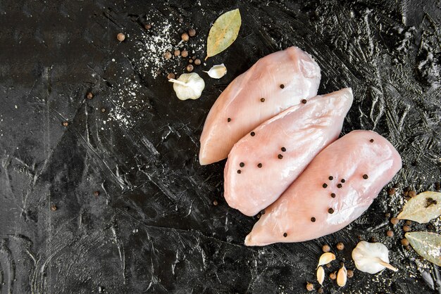 Filete de pollo crudo aislado en negro