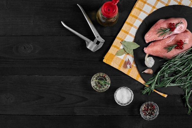 Filete de pollo crudo con ingredientes de cocina en la mesa de pizarra negra Fondo de alimentos Vista superior espacio de copia Bodegón Plano