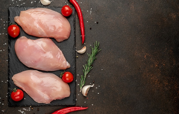 Filete de pollo crudo sobre fondo de piedra con espacio para copiar el texto