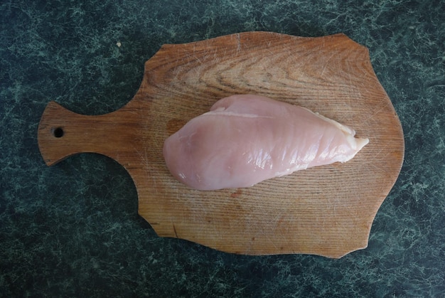 Foto filete de pollo crudo en una tabla de cortar