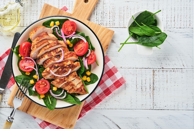 Filete de pollo con ensalada de espinacas, tomates cherry, aciano y cebolla