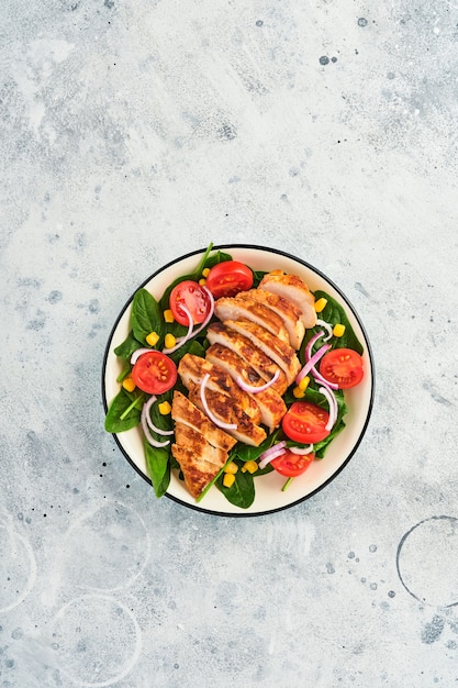 Filete de pollo con ensalada de espinacas, tomates cherry, aciano y cebolla