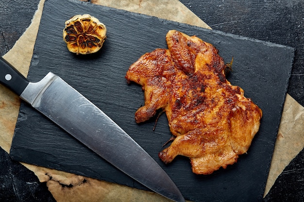 Filete de pollo con papas fritas en una superficie negra