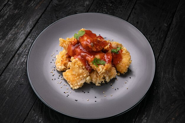 Filete de pollo a la plancha con salsa sobre un fondo oscuro