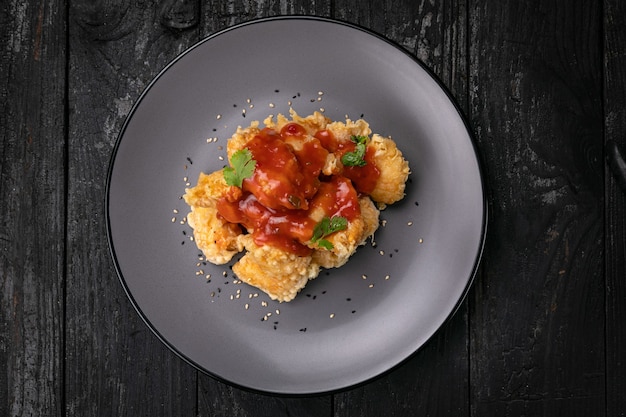 Filete de pollo a la plancha con salsa sobre un fondo oscuro