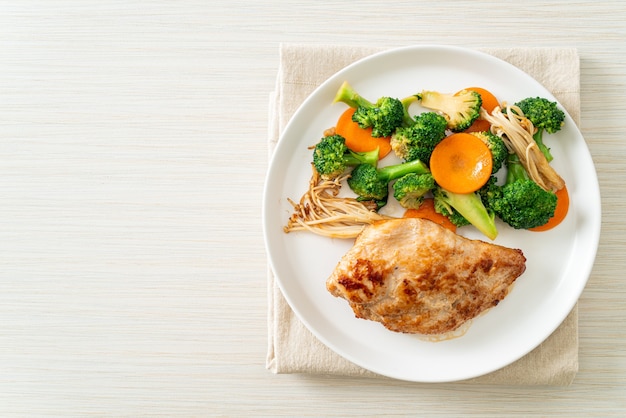 Filete de pollo a la plancha con verduras en la placa blanca.