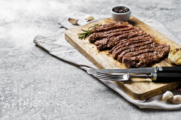 Filete rebanado del Bbq en la tajadera de madera.