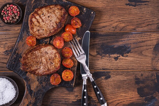 Filete de res cocido con tomate en tabla de cortar