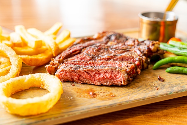 filete de res medio raro con vegetales y papas fritas