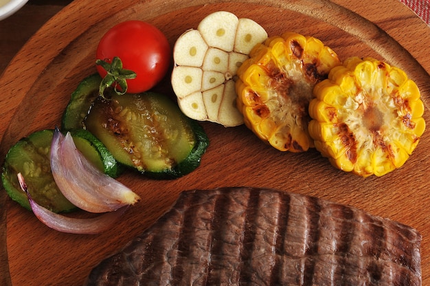 Filete de res a la parrilla, cortado en trozos, verduras a la parrilla: calabacín, maíz, cebolla, ajo, cereza