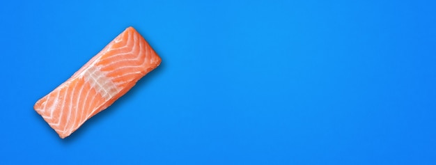 Filete de salmón aislado sobre fondo azul. Vista superior. Banner horizontal