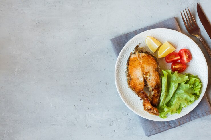 Filete de salmón al horno pescado en un plato con verduras frescas.