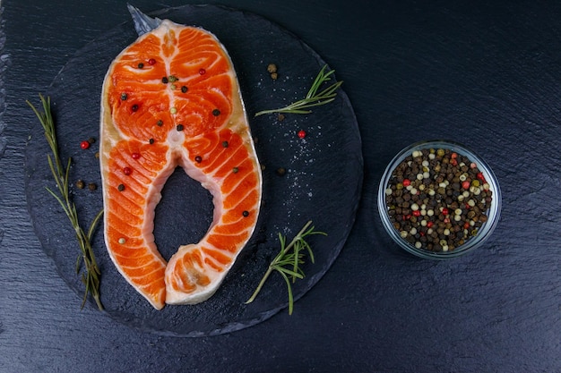 Filete de salmón crudo con especias en pizarra negra Vista superior